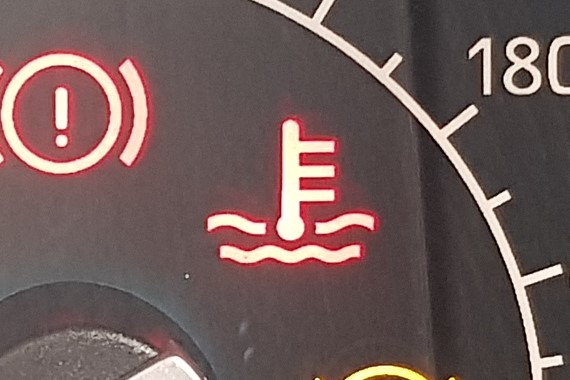 Warning light that looks like a thermometer coming out of some waves.